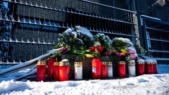 Flowers and candles in front of the entrance to a Jehovah's Witnesses building in Hamburg where there was a killing spree on March 9. © Daniel Bockwoldt/dpa